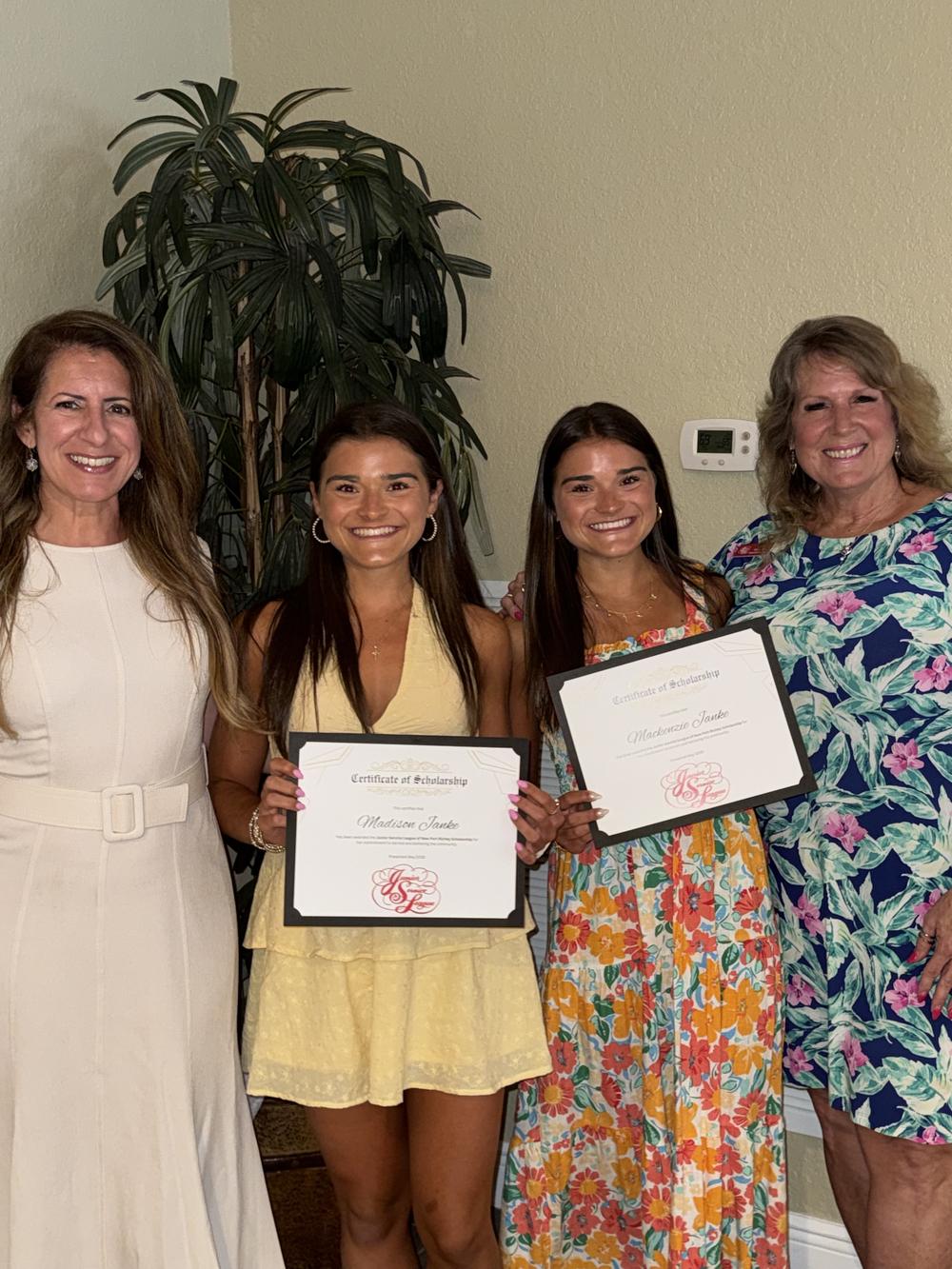 Two graduating seniors hold their JSL certificates of scholarship, flanked by a JSL member and a family member at the awards reception
